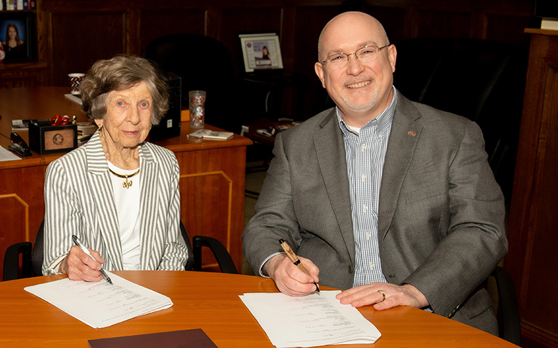 Mary W. Solomon with Michael Hartline during a signing ceremony