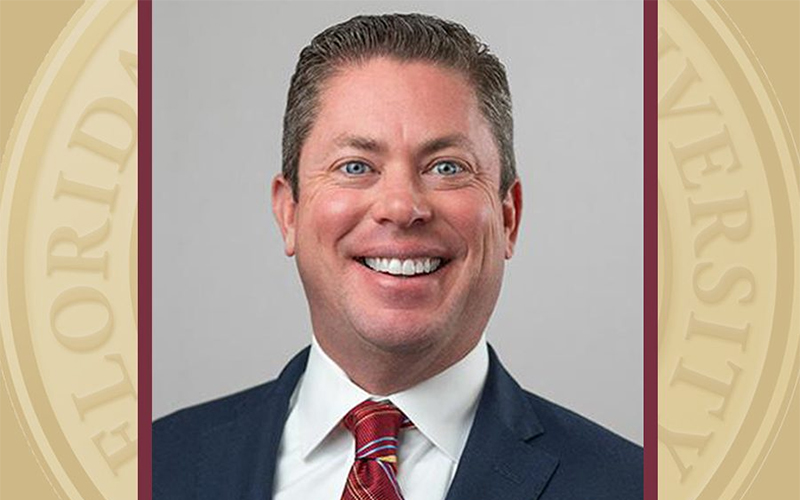 Headshot of smiling man in suit and tie