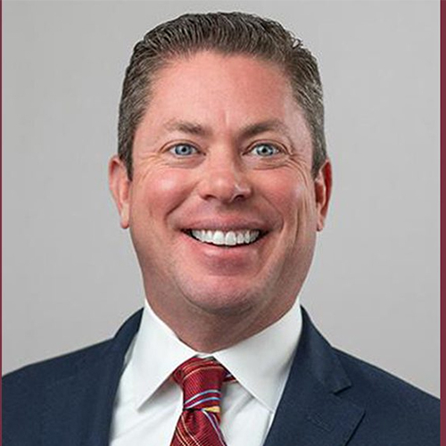 Headshot of smiling man in suit and tie