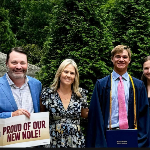 A group of four people holding a sign